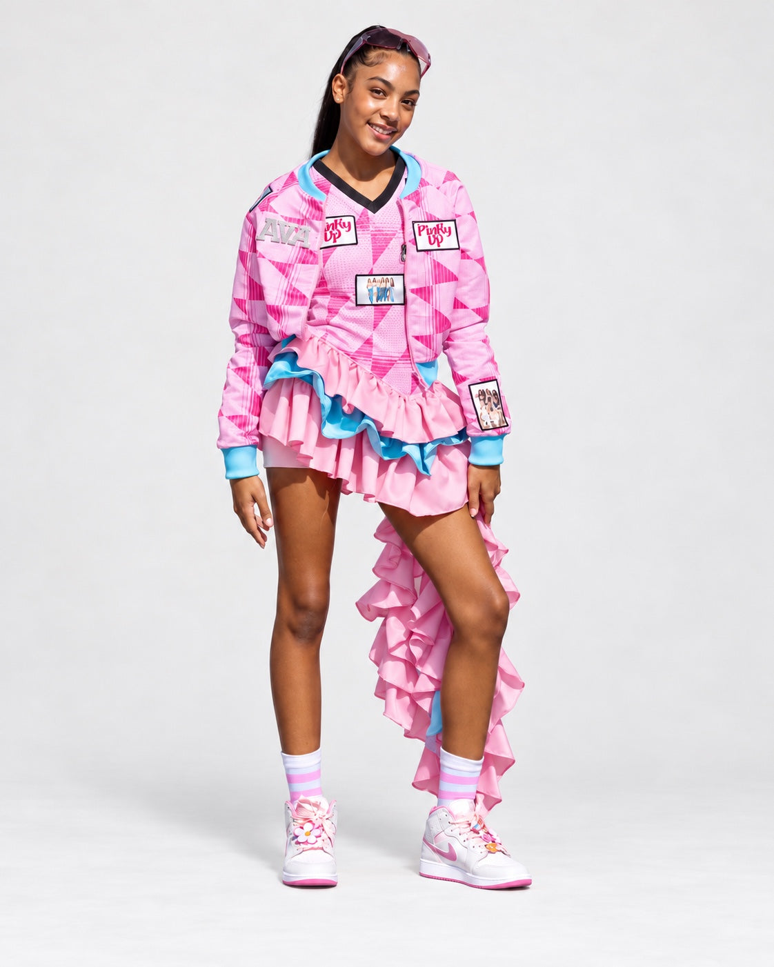 Pink Encore ruffle dress and matching bomber jacket with pink geometric print, blue accents, and a cascading ruffle train.